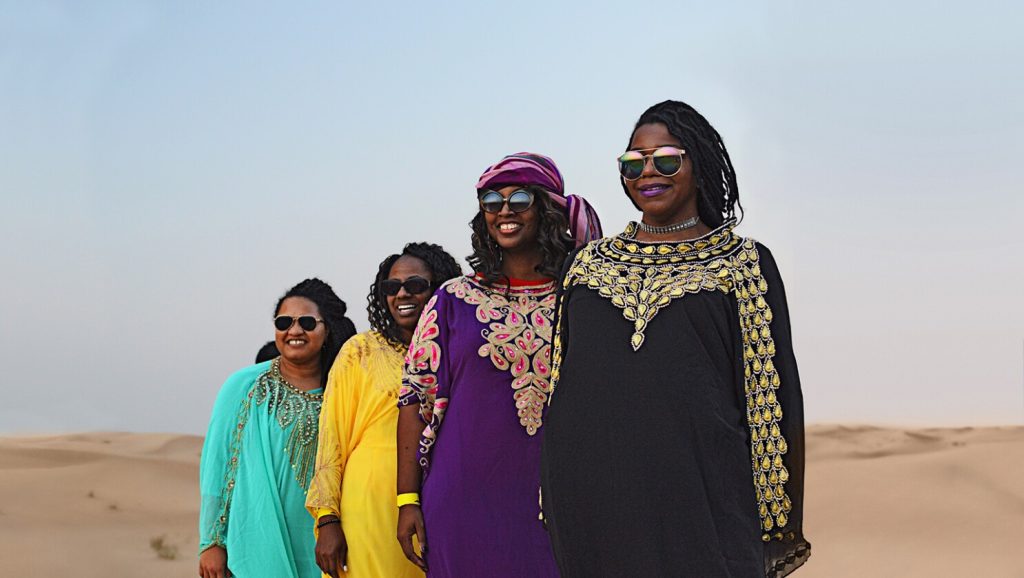 What should women wear in public areas in UAE?